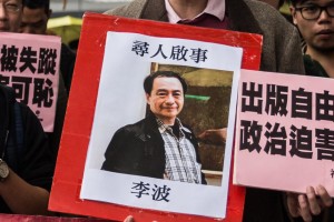 In this picture taken on January 3, 2016, a protestor holds up a missing person notice for Lee Bo, 65, the latest of five Hong Kong booksellers from the same Mighty Current publishing house to go missing, as they walk towards China's Liaison Office in Hong Kong. Britain confirmed on January 5 that one of five missing Hong Kong booksellers feared detained by Chinese authorities is a UK citizen, saying it was "deeply concerned" over the disappearances. AFP PHOTO / ANTHONY WALLACE / AFP / ANTHONY WALLACE (Photo credit should read ANTHONY WALLACE/AFP/Getty Images)